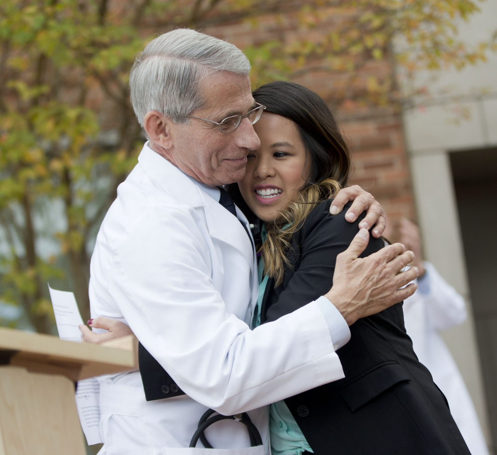 Patient Nina Pham is hugged by Dr. Anthony Fauci, director of the National Institute of Allergy and Infectious Diseases, outside of National Institutes of Health in Bethesda, Md., on Friday. Pham, the first nurse diagnosed with Ebola after treating an infected man at a Dallas hospital, is free of the virus.