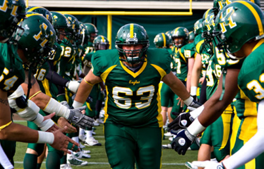 Husson University offensive lineman Matt Archer runs onto the field prior to a game earlier this season. Archer and the Eagles lead the ECFC in offense at 356.7 yards per game, and rushing, 204.8 yards per game.