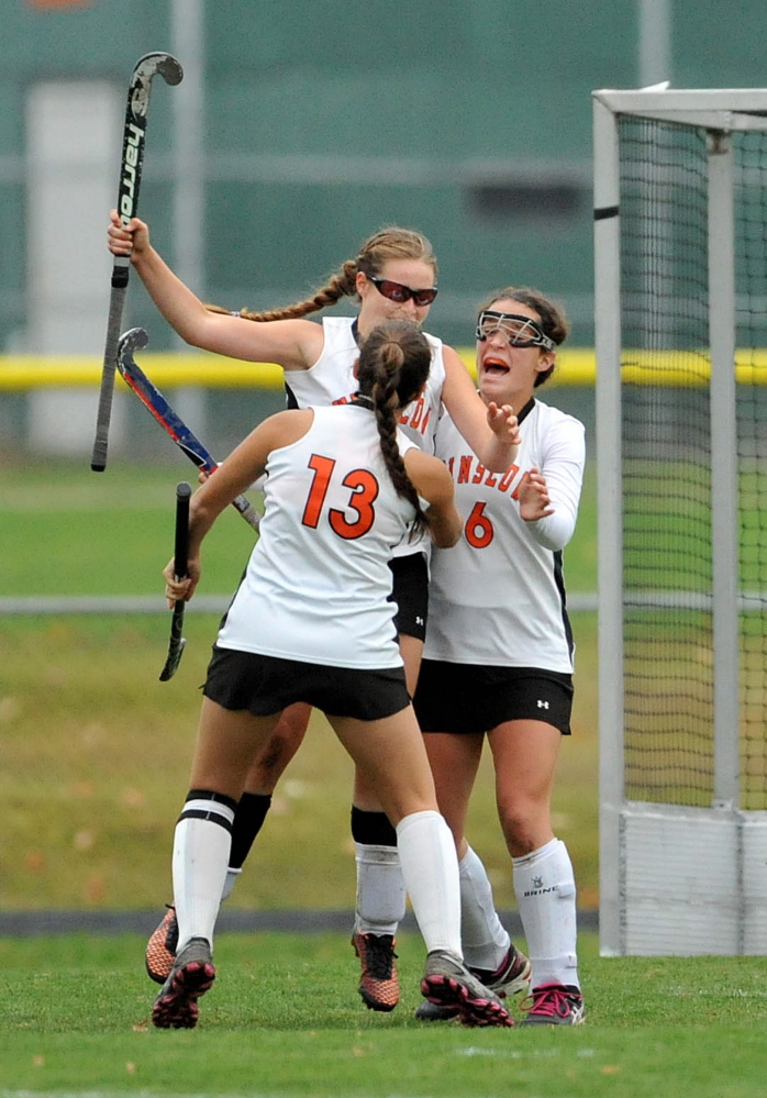 Winslow’s Jessica Greeley, facing far left, jumps into the arms of teammates Alyssa Wood (13) and Mackenzie Winslow (6) after scoring the game-winning overtime goal against Mount View in an Eastern C semifinal game Tuesday in Winslow.