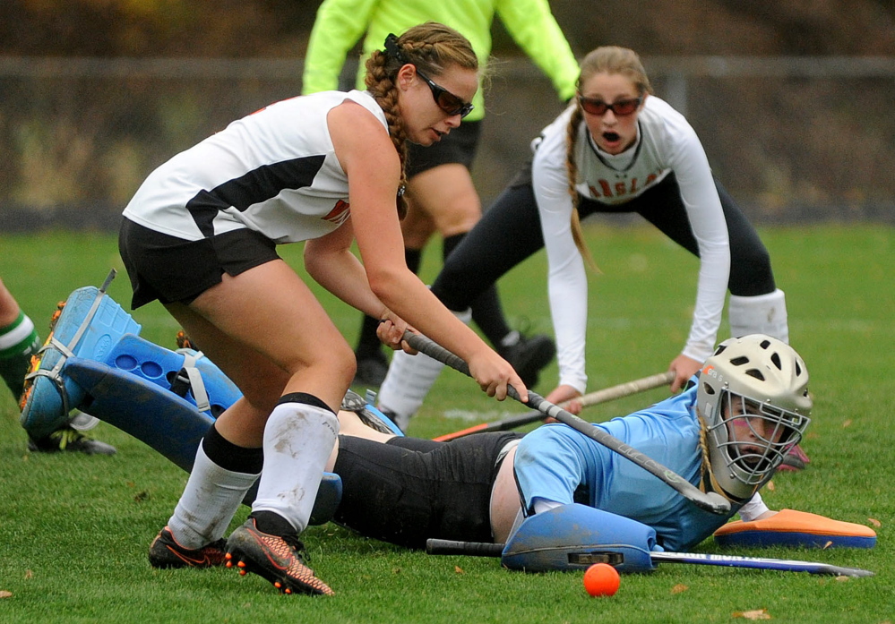 Mount View goalie Dinah Bilodeau makes a save as Winslow’s Jessica Greeley, left, looks for the rebound late in the second half of an Eastern C semifinal game Tuesday in Winslow. The Raiders prevailed 2-1 in overtime.