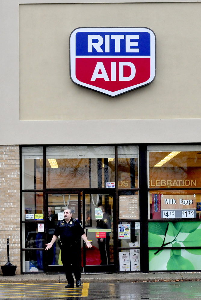 Skowhegan Deputy Police Chief Donald Bolduc instructs pedestrians to leave the parking lot of the Rite Aid store in Skowhegan following a report of a robbery on Wednesday afternoon.