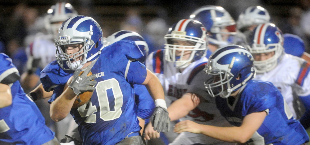 Lawrence High School’s Cole Robinson (40) powers through the line against Messalonskee High School during a recent game. Robinson, a second generation player at Lawrence, has played in a variety of roles, helping the Bulldogs to the playoffs.