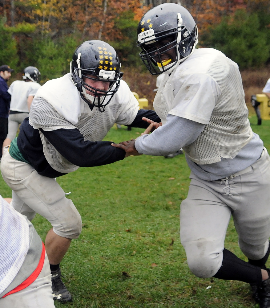 Staff photo by Andy Molloy 
 Maranacook senior linemen Josh Murphy, left, tags teammate Josh Ehriorobo during practice Wednesday. Murphy is a two-way starter while Ehriorobo is making an impact in his first year on the playoff-bound Black Bears.
