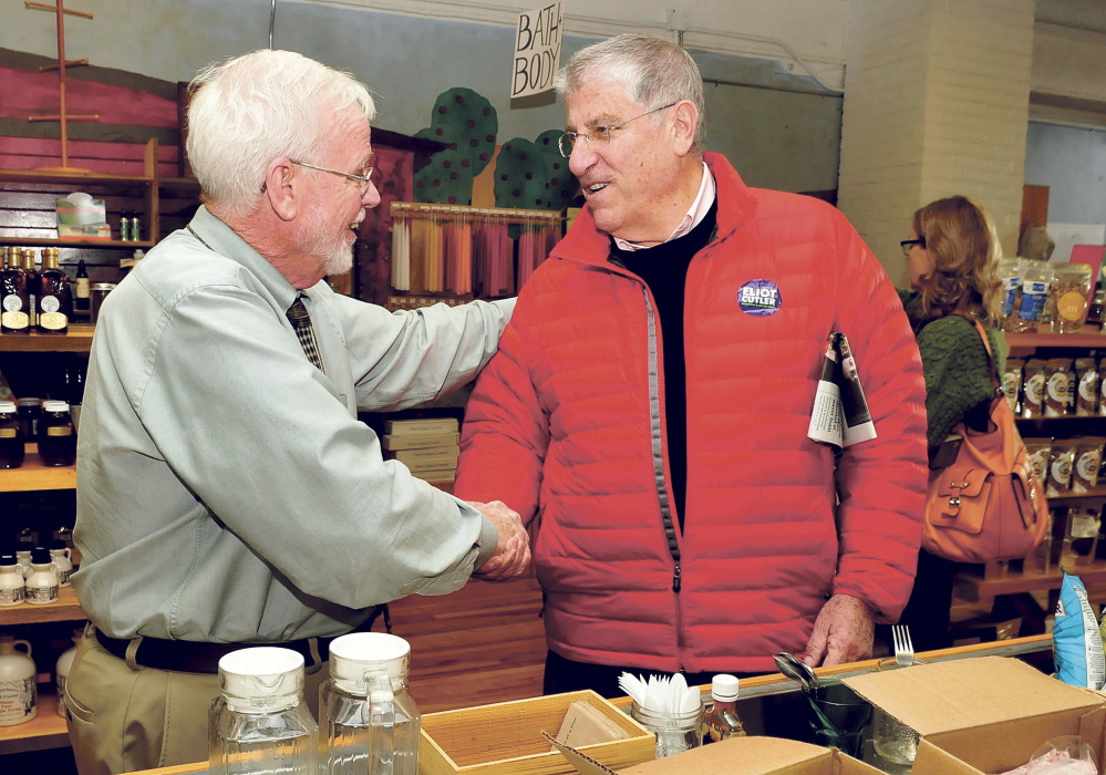 Jim Nicholson, left, shakes hands with gubernatorial candidate Eliot Cutler who was meeting with voters in Waterville on Thursday.