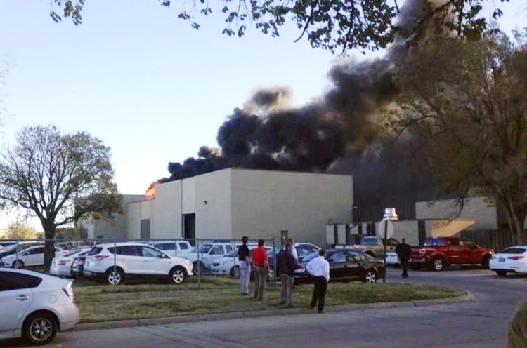 A fire official says at least two are dead inside this building at the Mid-Continent Airport in Wichita, Kansas, where a small plane crashed Thursday. The Associated Press / KAKE News