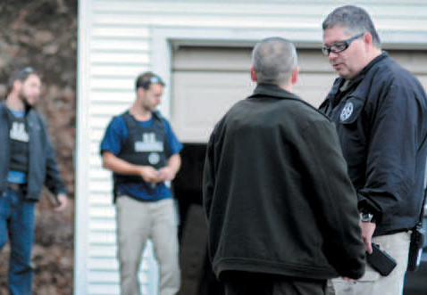 In this Nov. 2012 file photo, U.S. Marshals Service investigators search the residence of Barbara Cameron, the ex-wife of James Cameron, in Hallowell. Authorities spent more than two weeks looking for Cameron in 2012 after he cut off his electronic monitoring bracelet and drove to New Mexico before being captured. Maine's former top drug prosecutor fled the state after learning his appeal of child pornography convictions had failed. 