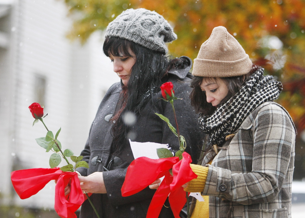 asdfasfd .... PORTLAND, ME - NOVEMBER 2: Friends of a victim prepare to lay flowers and a note at a vigil at 20 Noyes Street Sunday, November 2, 2014 following a deadly fire that killed five people. (Photo by Jill Brady/Staff Photographer)