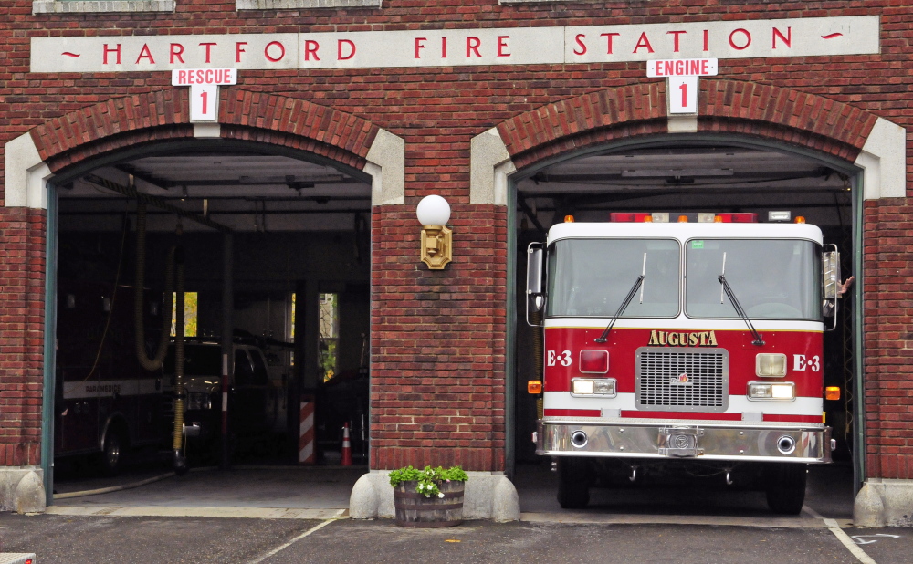 Augusta firefighter/paramedic Kevin Curry touches the wall to show what a tight fit it is as he moves Engine 3 to another bay in this October file photo at Hartford Station in Augusta. City voters Tuesday agreed to pay for a new fire station.