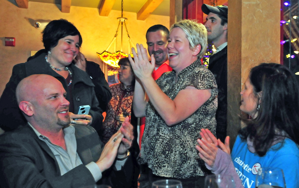 Charlotte Warren, center, and her supporters celebrate her win in House District 84 late Wednesday at Joyce’s in Hallowell.