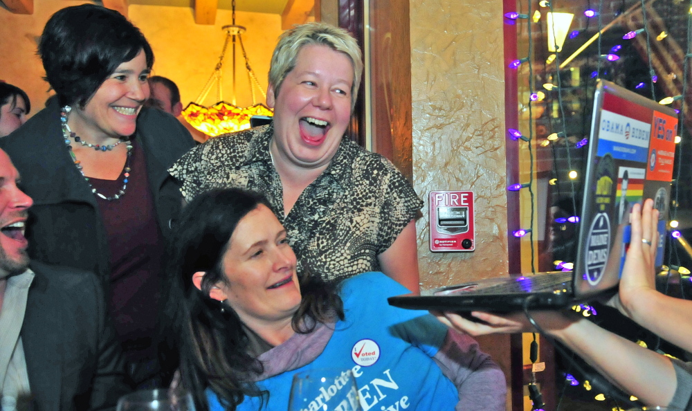 Stacey Goldberg-Doyle, top left, Charlotte Warren and Juliette Guilmette, bottom, look at a laptop showing the centralmaine.com website listed Warren as winning in House District 84 late Wednesday at Joyce’s in Hallowell.
