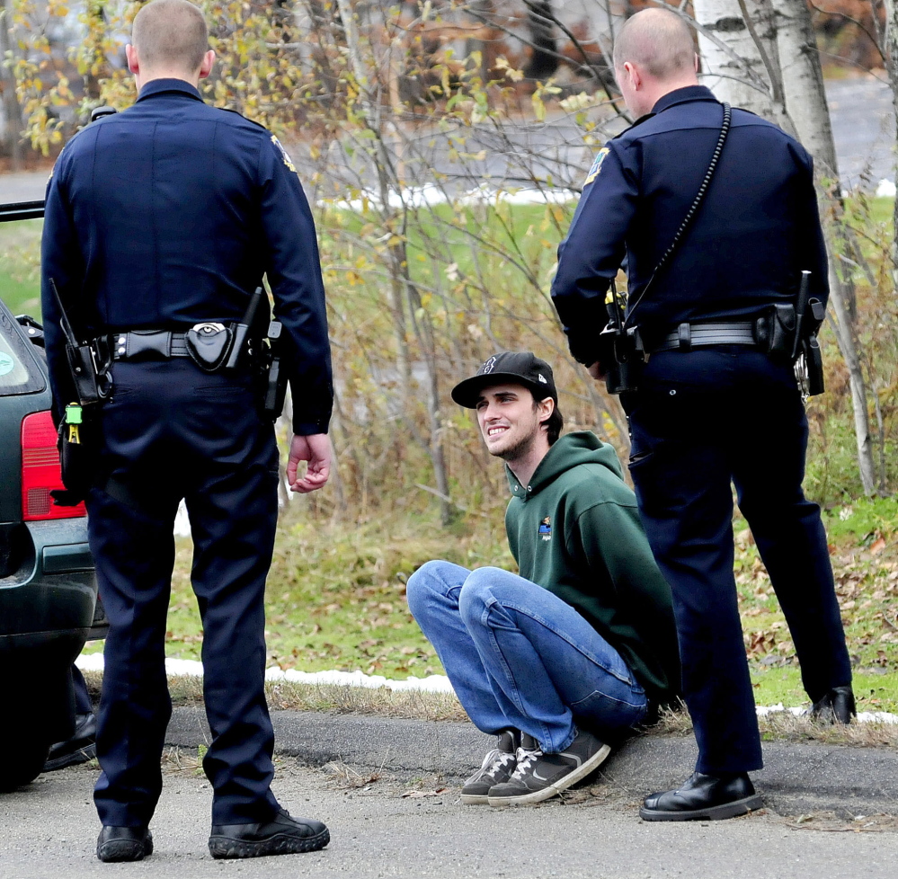 Waterville police officers speak with Joseph Ciampa, handcuffed outside his vehicle on Airport Road in Waterville .