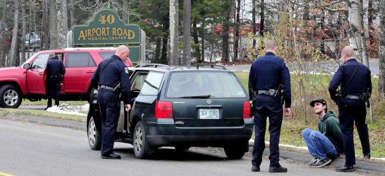 Joseph Ciampa is interviewed by Waterville police as an officer searches a car on Airport Road in Waterville on Wednesday while an officer also interviews the driver of another vehicle in the background after a motorist reported he was threatened with a gun.