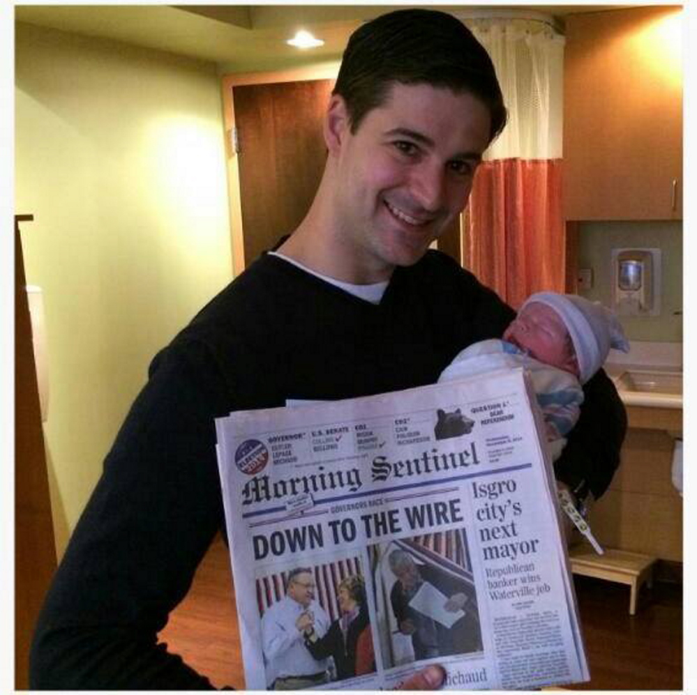 Waterville mayor-elect Nick Isgro with his newborn son on Wednesday and the Morning Sentinel front page.