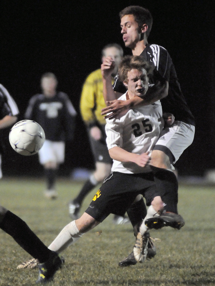 Maranacook Community High School’s Matty DuBois can’t knock the ball out of the hands of Hall-Dale High School keeper Brian Allen after bypassing defensemen Alex Guiou Wednesday during the Western C boys soccer championship game in Readfield.