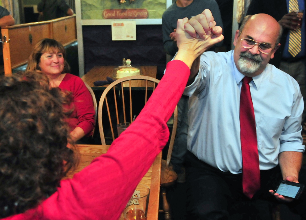 Augusta mayoral candidate Dave Rollins, right, high-fives his wife, Jan Rollins, on Tuesday night at Lisa’s Restaurant and Catering in Augusta after election results come in. Rollins won the election.
