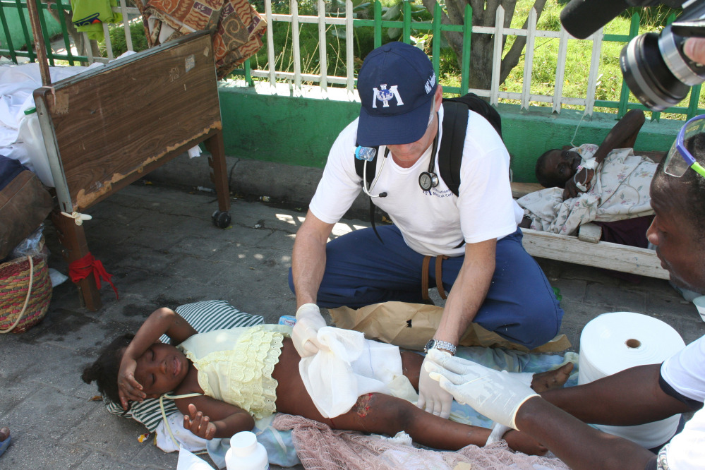 Dr. Robert Fuller provides medical care to an earthquake survivor in Port-au-Prince, Haiti, in January 2010. Three weeks of quarantine imposed on medical professionals who volunteer to go to West Africa to help care for Ebola patients adds to the complications of volunteering. It isn’t likely that Fuller will be able to participate if he is required to be away from the University of Connecticut Emergency Medical Department for nine straight weeks.