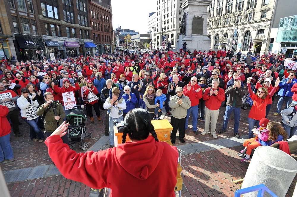 Kimberly Talbot with IBEW local 2327, sings to the crowd to get them fired up as striking Fairpoint union workers rally at Monument Square on Saturday.