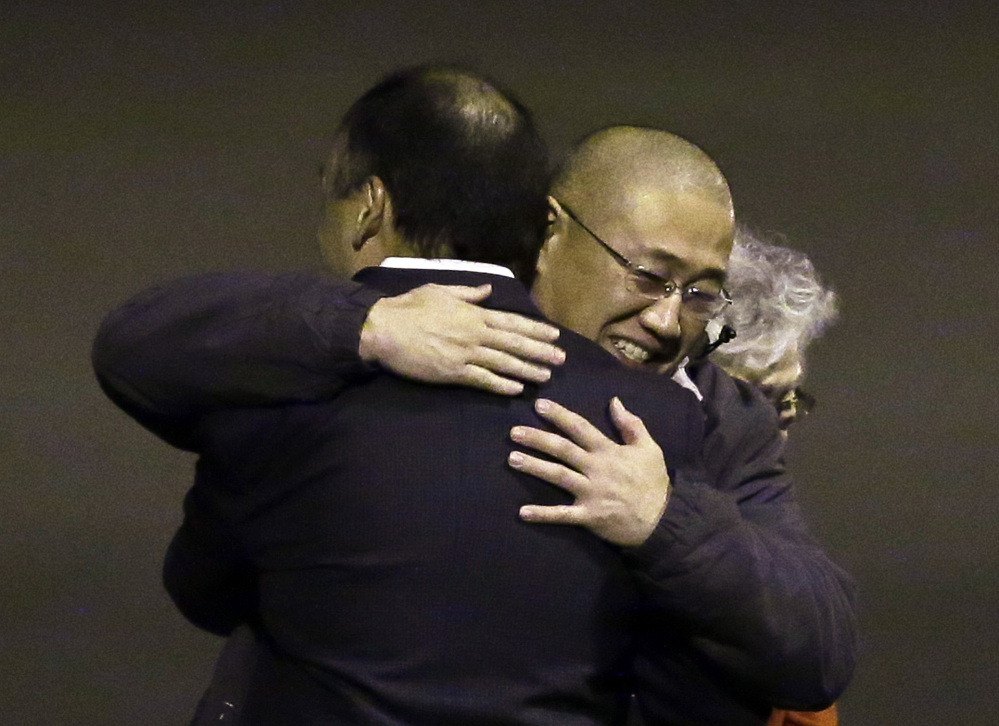 Kenneth Bae, center, who had been held in North Korea since 2012, is hugged after arriving Saturday at Joint Base Lewis-McChord, Wash.