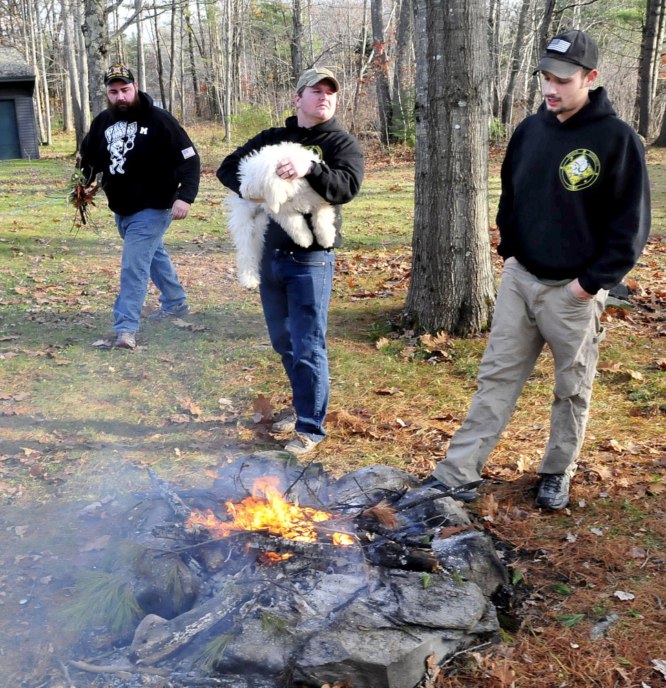 Marine Corps veterans, from left, Ryan Doucette, Chris Duffy and Josh Carrier gather on Monday for a barbecue. The three and a fourth friend, Mike Jacques, of Waterville, have each other to lean on when things get rough, and all bear remembrances of comrades who died in the Traq and Afghanistan wars..