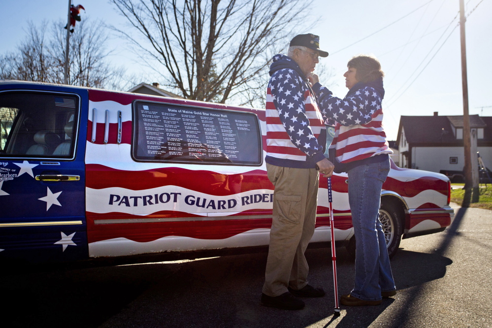 Rita Dearborn fusses over her husband’s American flag sweatshirt on Saturday as they stand in front of his 1997 Lincoln Town Car Limousine that Larry Dearborn drives around the state to honor veterans of America’s wars. The Dearborns plan to take part in this year’s parade in Richmond.