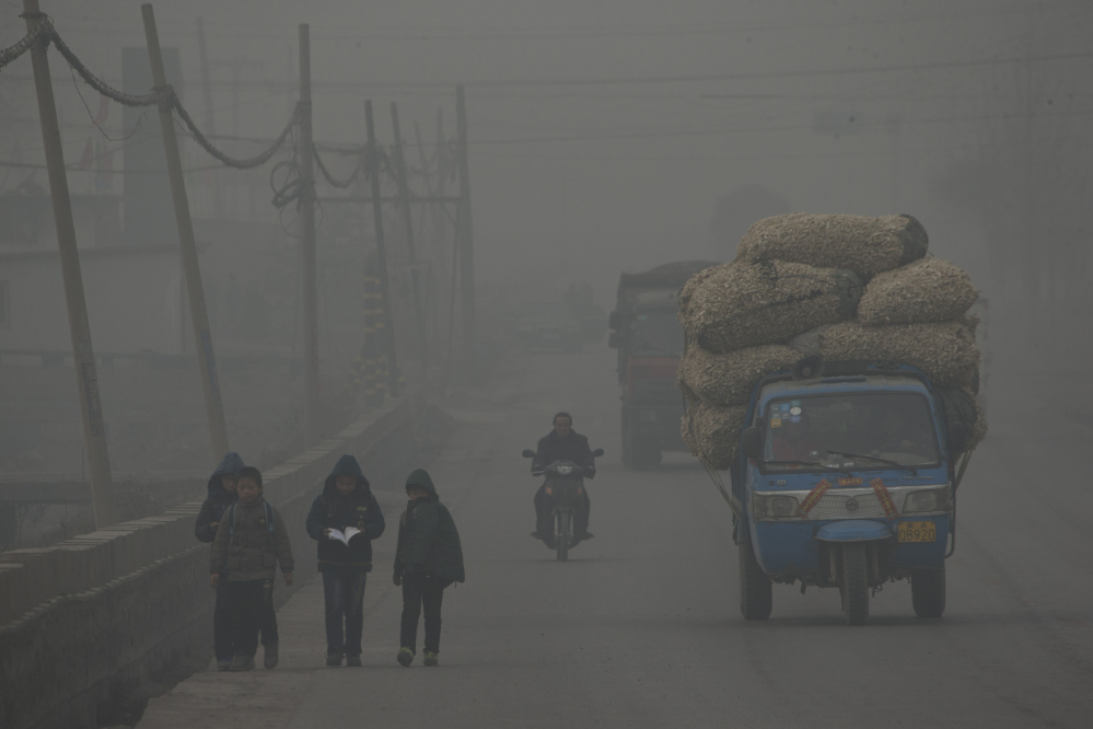 Children walk home after school on a severely polluted day in Shijiazhuang, in northern China’s Hebei province. A groundbreaking agreement struck Wednesday by the United States and China puts the world’s two worst polluters on a faster track to curbing the heat-trapping gases blamed for global warming.