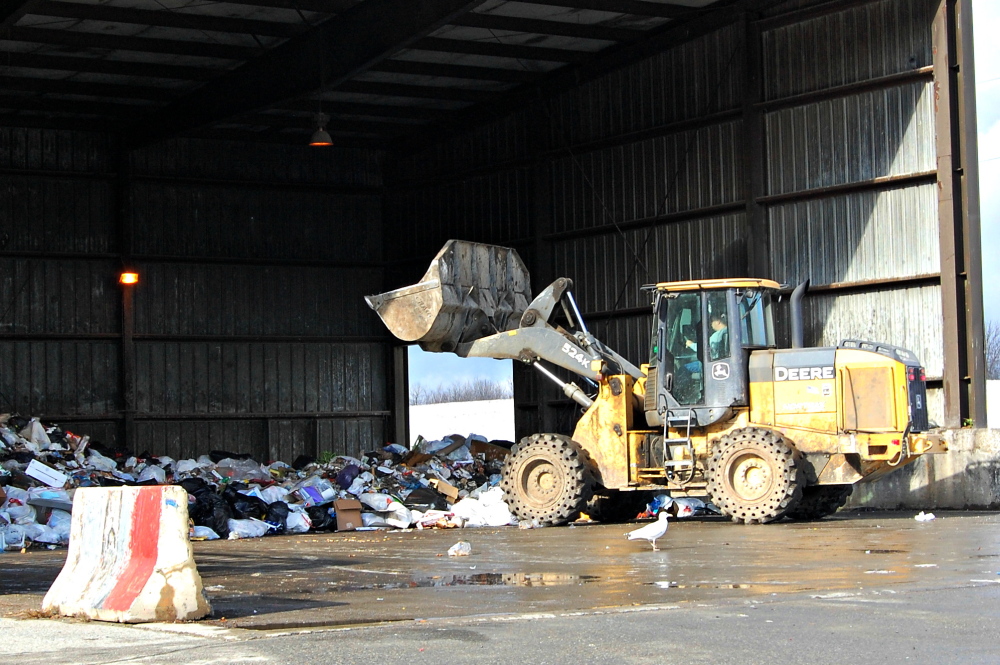 Workers at the Oakland transfer station prepare garbage for transport to an incinerator in Orrington. Garbage volume — and fee collections — are down since Waterville started requiring residents to pay for trash removal through mandatory use of official city trash bags.