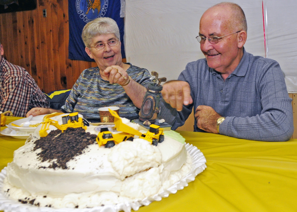 Herb Whittier, right, and his sister, Betsey Deisinger, look at the cake at his retirement party on Friday at Monmouth Fish and Game Club in Monmouth.