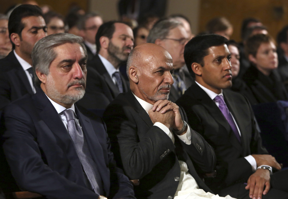Afghan President Ashraf Ghani, center, sits next to chief executive Abdullah Abdullah, left, his former rival while attending an event in Kabul, Afghanistan, this month. Ghani and Abdullah are restructuring the country’s long-troubled government.