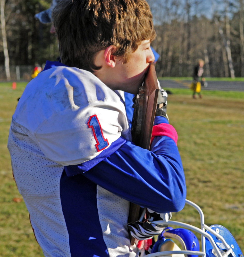Staff photo by Joe Phelan 
 Oak Hill kicker Adam Merrill kisses the plaque after the Raiders won the Western D championship game Saturday in Lisbon. His point after conversion made the difference in a 7-6 victory.