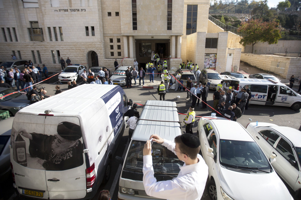 An ultra-Orthodox Jewish youth takes a picture at the scene of a shooting attack in a synagogue in Jerusalem.