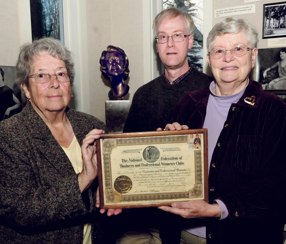 Members of the now-disbanded Skowhegan Chapter of Business and Professional Women of Maine organization Joan Slipp, left, and Marjorie Coburn Black hold an organization plaque Tuesday at the Margaret Chase Smith Library in Skowhegan. Library Director David Richards stands beside a sculpture of Smith, who co-founded the group in 1922.