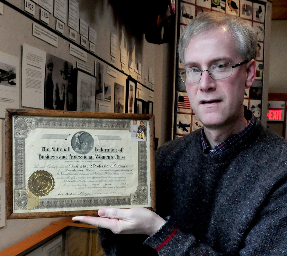 David Richards, director at the Margaret Chase Smith Library in Skowhegan holds a charter plaque of the now-disbanded Skowhegan Chapter Business and Professional Women of Maine organization on Tuesday. Smith was a founding member in 1922.