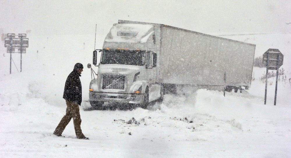 Omer Odovsc walks in front of his tractor trailer that got stuck on the 219 off ramp leading to Rt. 391 in Boston, N.Y. on Tuesday. The Buffalo Bills are doing all they can to clear off Ralph Wilson Stadium so the team can play the New York Jets on Sunday.