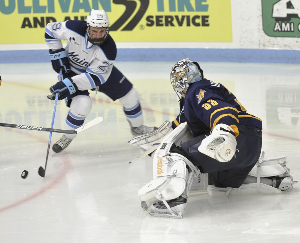 Maine winger Connor Leen (29) tries to stuff the puck around Quinnipiac goalie Eric Hartzell (33)  in the third period Saturday in Orono. Leen is second on the team with 32 shots on goal this season.