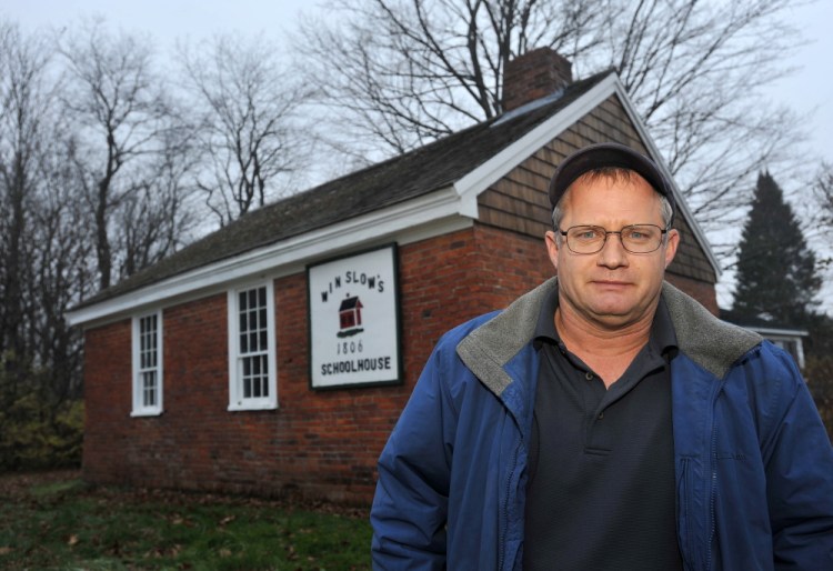 Winslow Councilman Raymond Caron, District 4, a former member of the now defunct Winslow Historical Society, stands in front of the Winslow schoolhouse . The school house dates to the early 1800s. File photo by Michael G. Seamans