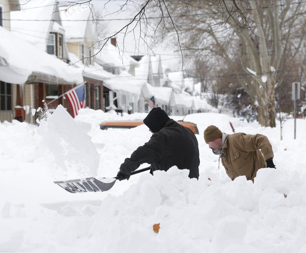 Mark Petrik and Dennis Smith dig out their driveway on Saturday in Buffalo, N.Y. Western New York continues to dig out from the heavy snow dropped by this week by lake-effect snowstorms.