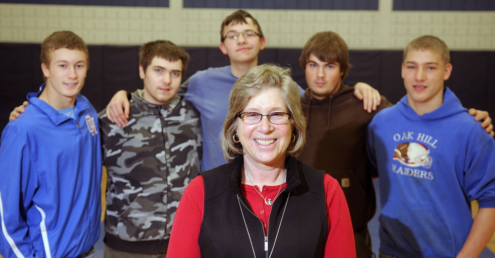 Wendy Jacobs, who coached a team of Oak Hill students at the Southern Maine Unified Basketball Tournament last spring, poses with some of her players during a practice earlier this month at the school.
