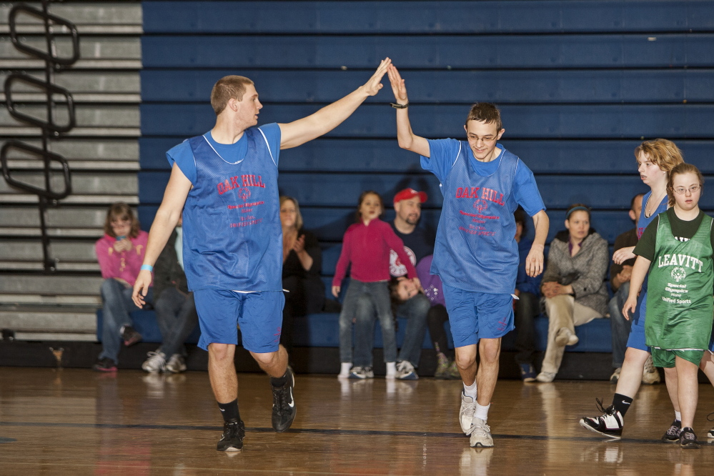 Members of an Oak Hill Special Olympics basketball team congratulate each other during a game in the Southern Maine Unified Basketball Tournament in April 2013 at the University of Southern Maine.