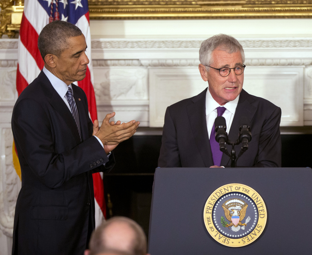 President Obama applauds Defense Secretary Chuck Hagel at the White House on Monday as Hagel’s resignation is announced. Hagel is stepping down under pressure after struggling to break through the White House’s insular foreign policy team.