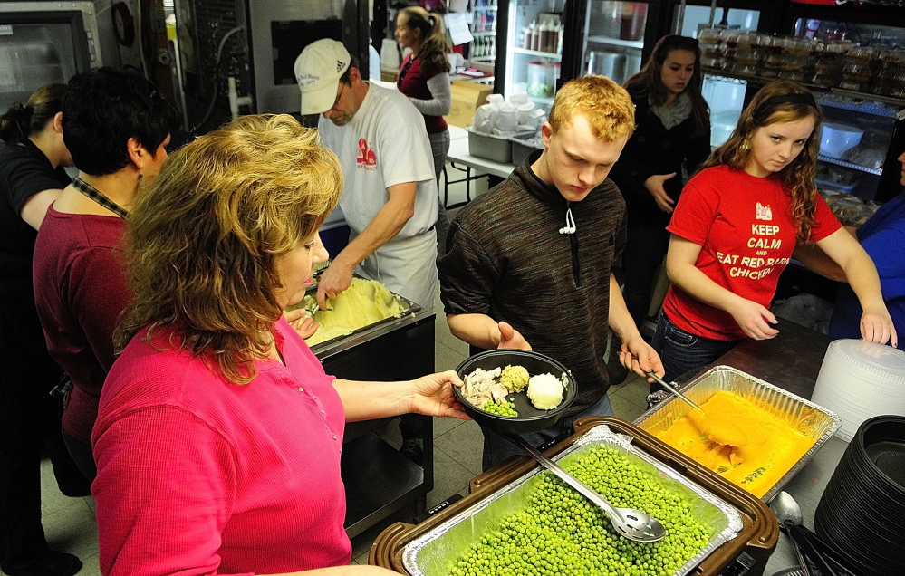 Volunteers load up turkey dinners on plates for the 2013 community Thanksgiving dinner at The Red Barn restaurant in Augusta. The menu included turkey, stuffing, potatoes, peas and squash.