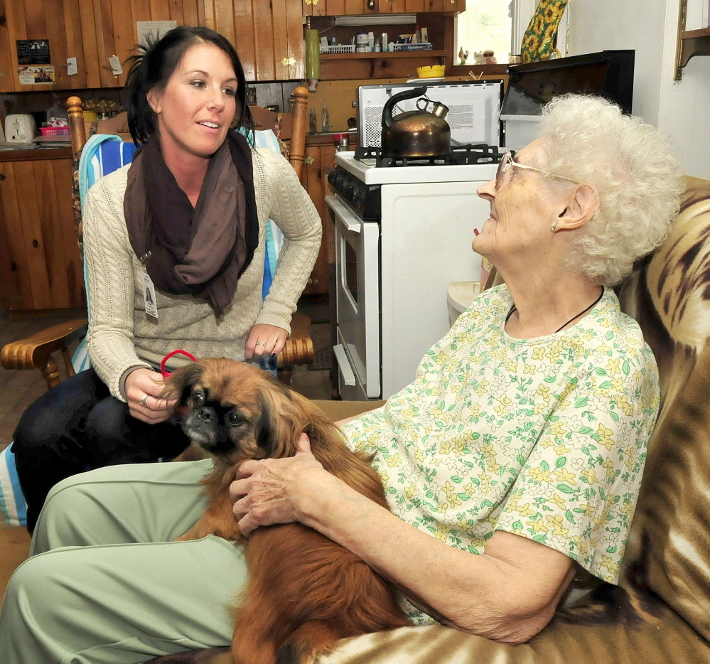 Ashley Conners, left, regional nutrition assistant with the Meals on Wheels program, speaks with recipient Eurline Perkins at her home in Skowhegan on Tuesday.