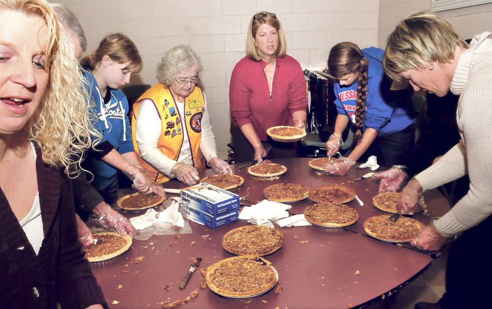 Volunteers slice and box dessert pies Thursday during the annual Thanksgiving dinner sponsored by Bud King and the Oakland Lions Club at Messalonskee High School in Oakland.