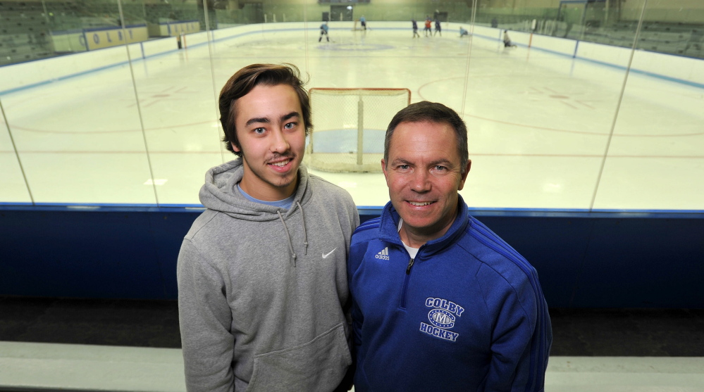 Staff photo by Michael G. Seamans 
 Colby College hockey coach Blaise MacDonald, right, stands with his son and Colby forward Cam MacDonald before a recent practice.