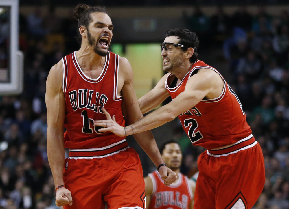 Chicago Bulls center Joakim Noah, left, celebrates with guard Kirk Hinrich after making a crucial basket in the last minute of a basketball game against the Boston Celtics in Boston on Friday. The Bulls won 109-102.