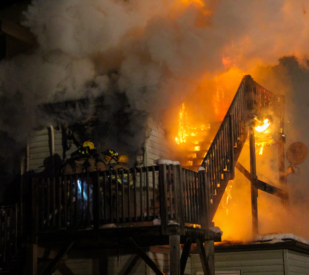 Firefighters make their way into a second-floor apartment during an apartment house fire in Berwick late Friday.