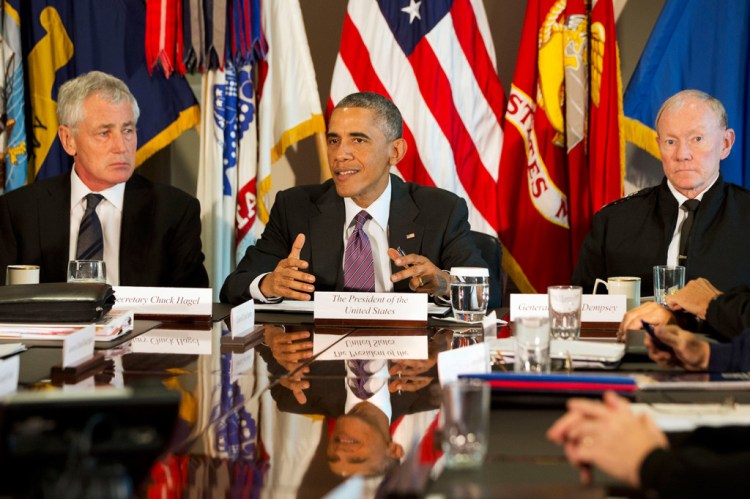 In this Oct. 8, 2014 file photo, President Barack Obama, flanked by Defense Secretary Chuck Hagel, left, and Joint Chiefs Chairman Gen. Martin Dempsey, speaks to the media at the conclusion of a meeting with senior military leadership, at the Pentagon. Defense Secretary Hagel is resigning from the Obama Cabinet Monday. The Associated Press
