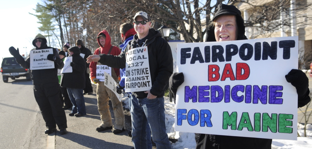 Krista MacKay, of South Gardiner, right, holds a sign while picketing Tuesday outside a health care conference in Augusta sponsored in part by FairPoint Communications.