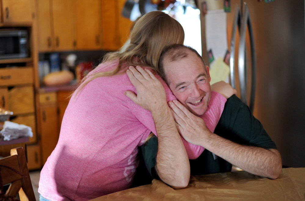 Scott Greaney gets a hug from daughter Emily at the family dining room table before the Thanksgiving feast, the family’s first “real meal” in a week.