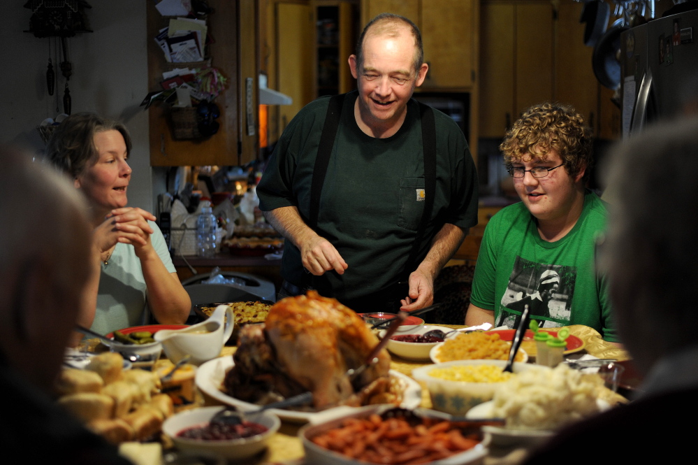MERCER, MAINE - NOVEMBER 27, 2014. 
 Scott Greaney prepares to carve the family bird as his wife Tracey, left, and son Ben, 15, right, watch during Thanksgiving dinner at the family's home in Mercer on Thursday, Nov. 27, 2014. (Staff photo by Michael G. Seamans)