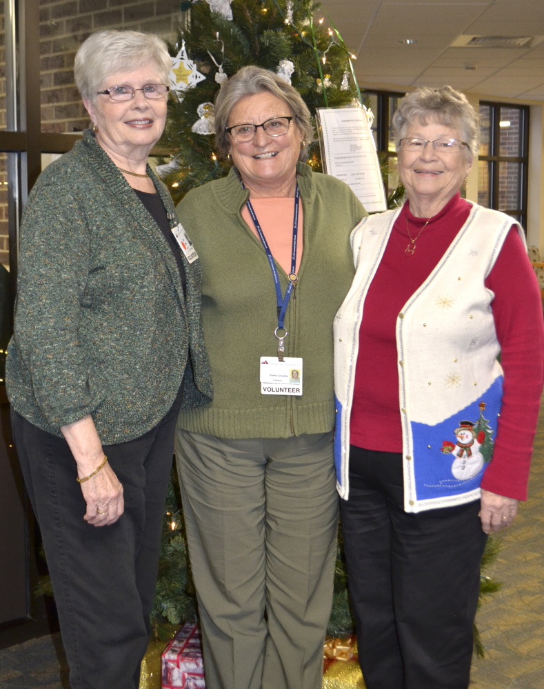 From left Auxiliary members Jean Rand, Dawn Girardin and Mary Harris in front of the Remembrance Tree.